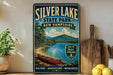 A vintage-style metal sign for Silver Lake State Park in New Hampshire, featuring a scenic image of a lake, mountains, and a red canoe.
