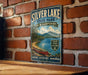 A vintage-style metal sign for Silver Lake State Park in New Hampshire, featuring a scenic image of a lake, mountains, and a canoe.