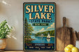 A vintage-style sign for Silver Lake State Park in New York, featuring a scenic illustration of a lake, trees, and a sailboat.