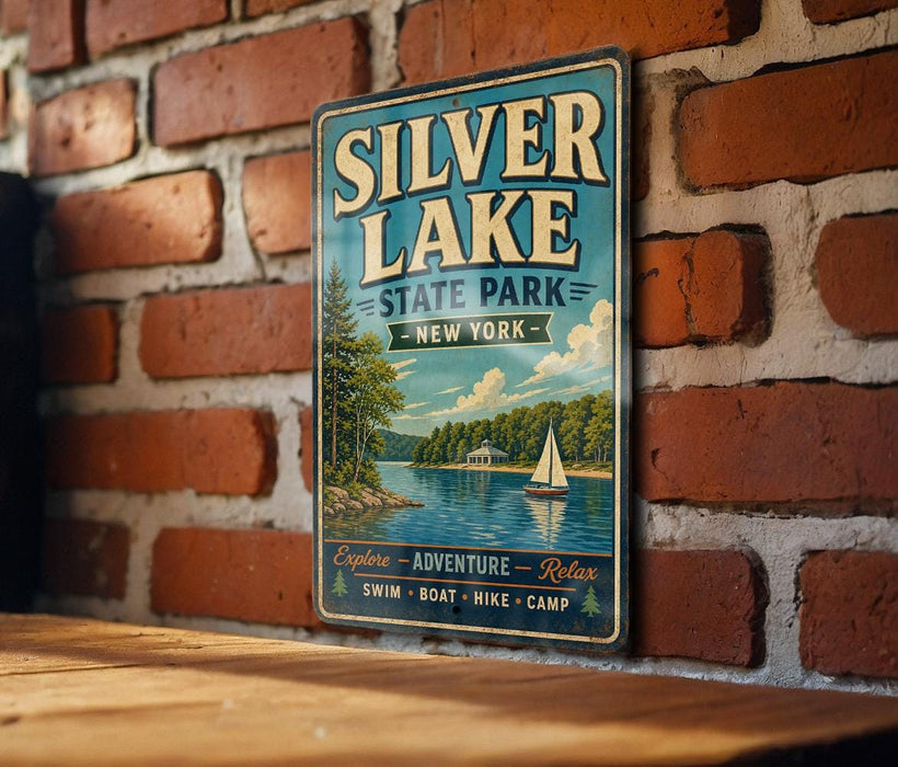 A vintage-style metal sign for Silver Lake State Park in New York, featuring a scenic illustration of a lake with a sailboat and a forested shoreline.