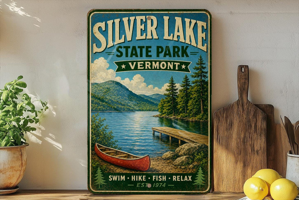 A vintage-style sign for Silver Lake State Park in Vermont, featuring a scenic image of a lake, mountains, and a canoe.