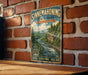 A vintage-style metal sign for Sinnemahoning State Park in Pennsylvania, featuring a scenic illustration of a river and forest landscape.