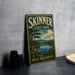 A vintage-style sign for Skinner State Park in Hadley, Massachusetts, featuring a scenic landscape with a lake and mountains.