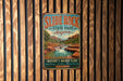 A vintage metal sign for Slide Rock State Park in Arizona, featuring a scenic image of a waterfall and desert landscape.