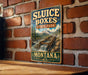 A vintage-style sign for Sluice Boxes State Park in Montana, featuring a scenic mountain landscape with a waterfall.