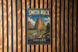A vintage metal sign for Smith Rock State Park in Oregon, featuring a scenic mountain landscape.