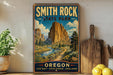 A vintage-style metal sign for Smith Rock State Park in Oregon, featuring a scenic mountain landscape with a winding path and a river.