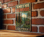A vintage-style metal sign for Smithe Redwoods State Natural Reserve in California, featuring a scenic image of the redwood forest.