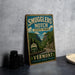 A vintage-style sign for Smugglers' Notch State Park in Vermont, featuring a scenic mountain landscape.
