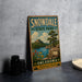 A vintage-style sign for Snowdale State Park in Oklahoma, featuring a scenic landscape with a lake, mountains, and a tree.