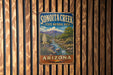 A vintage metal sign for Sonoita Creek, a state natural area in Arizona, is displayed on a wooden wall.