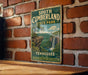 A vintage-style metal sign for South Cumberland State Park in Tennessee, featuring a scenic illustration of a waterfall and mountains.