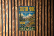 A vintage metal sign for South Fork State Recreation Area in Nevada, featuring a scenic landscape with mountains, trees, and a river.
