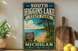 A vintage-style sign for South Higgins Lake State Park in Michigan, featuring a scenic beach and lake landscape.