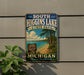 A vintage metal sign for South Higgins Lake State Park in Michigan, featuring a scenic beach and lake landscape.