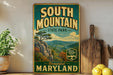 A vintage-style metal sign for South Mountain State Park in Maryland, featuring a scenic mountain landscape with a pine tree and a wooden cutting board.