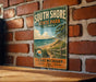 A vintage metal sign for South Shore State Park in Illinois, featuring a scenic beach landscape with a path leading to the shore.