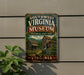 A vintage-style metal sign for the Southwest Virginia Museum, featuring a historical state park setting with a watermill and a cabin.