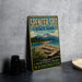 A vintage-style sign for Spencer Spit State Park, featuring a scenic landscape with mountains, a beach, and a body of water.