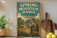 A vintage-style sign for Spring Mountain Ranch State Park in Nevada, featuring a scenic illustration of a mountain landscape with a small cabin and a sign that reads "Discover, Explore, Relax".