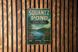 A vintage metal sign for Squantz Pond State Park in Connecticut, featuring a scenic illustration of the pond surrounded by trees and mountains.