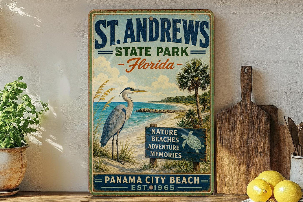 A vintage-style metal sign for St. Andrews State Park in Florida, featuring a beach scene with a heron and palm trees.