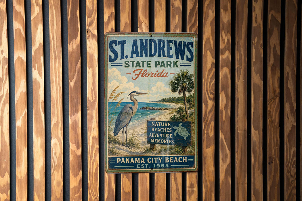 A vintage metal sign for St. Andrews State Park in Florida, featuring a blue heron and a beach scene, hangs on a wooden wall.