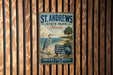 A vintage metal sign for St. Andrews State Park in Florida, featuring a blue heron and a beach scene, hangs on a wooden wall.