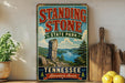 A vintage-style sign for Standing Stone State Park in Tennessee, featuring a scenic landscape with a lake and mountains.