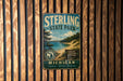 A vintage metal sign for Sterling State Park, featuring a scenic landscape with a lake and mountains in the background.