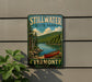 A vintage-style sign for Stillwater State Park in Vermont, featuring a scenic landscape with a canoe on a lake surrounded by pine trees.