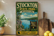 A vintage-style sign for Stockton State Park, Missouri, featuring a scenic lake and hiking trails.