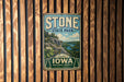 A vintage-style metal sign for Stone State Park in Iowa, featuring a scenic landscape with a river and mountains.