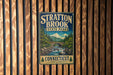 A vintage-style metal sign for Stratton Brook State Park in Connecticut, featuring a scenic landscape with a bridge and waterfall.