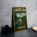 A vintage-style sign for Strouds Run State Park in Ohio, featuring a scenic landscape with a river and mountains.