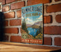 A vintage metal sign for Summer Lake State Park in New Mexico, featuring a scenic landscape with mountains, a lake, and a sailboat.
