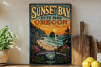 A vintage-style sign for Sunset Bay State Park in Oregon, featuring a scenic coastal landscape with a sunset over the ocean.