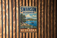 A vintage metal sign for the Swanson Reservoir State Recreation Area in Nebraska, featuring a scenic image of a lake and mountains.