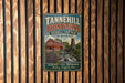 A vintage-style metal sign for Tannehill Ironworks Historic State Park in Alabama, featuring an illustration of a historic ironworks building and a waterfall.