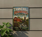 A vintage metal sign for Tannehill Ironworks, a historical state park in Alabama, featuring a red barn and a watermill.