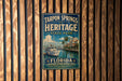 A vintage-style metal sign for Tarpon Springs Heritage State Park in Florida, featuring a boat and a coastal scene.