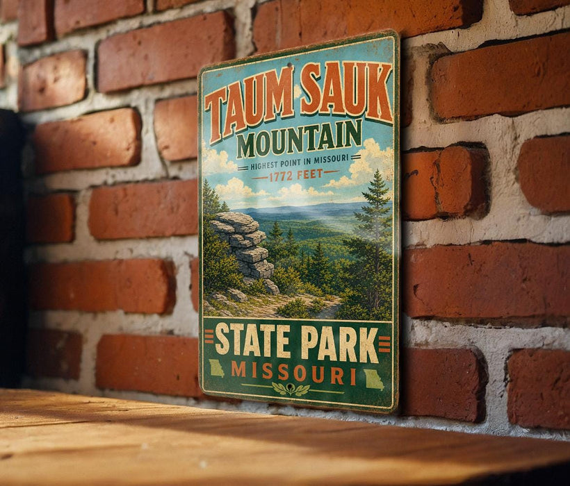 A vintage-style metal sign for Taun sauk mountain in Missouri, featuring a scenic landscape with pine trees and a rocky outcrop.