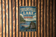 A vintage metal sign for Taylorville Lake State Park in Kentucky, featuring a scenic image of a lake with a boat and surrounded by trees.
