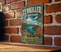 A vintage-style sign for Ten Killer State Park in Oklahoma, featuring a scenic landscape with a lake, mountains, and autumn foliage.