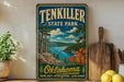 A vintage-style sign for Ten Killer State Park in Oklahoma, featuring a scenic landscape with a lake, mountains, and trees.