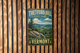 A vintage metal sign for Theftord Hill State Park in Vermont, featuring a scenic landscape with mountains, trees, and a river.