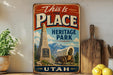 a vintage-style sign that reads "This is the Place Heritage Park Utah" with a wagon and a monument in the background.