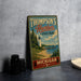 A vintage-style metal sign for Thompson's Harbor State Park in Michigan, featuring a lighthouse and a scenic landscape.