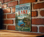 A vintage metal sign welcoming visitors to Thompson's Lake State Park in New York.