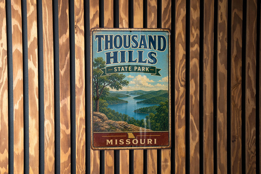 A vintage metal sign for Thousand Hills State Park in Missouri, featuring a scenic landscape with a lake and mountains.